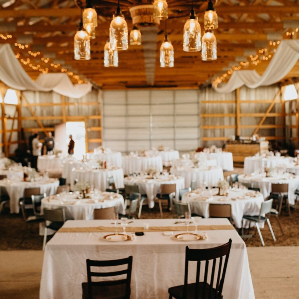 wedding couple and guest reception tables in barn venue