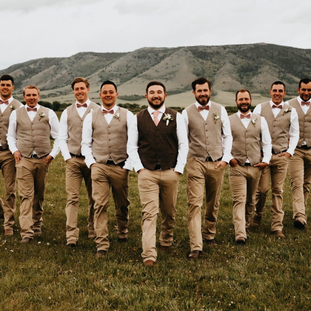 groom and groomsmen walking with mountains in background