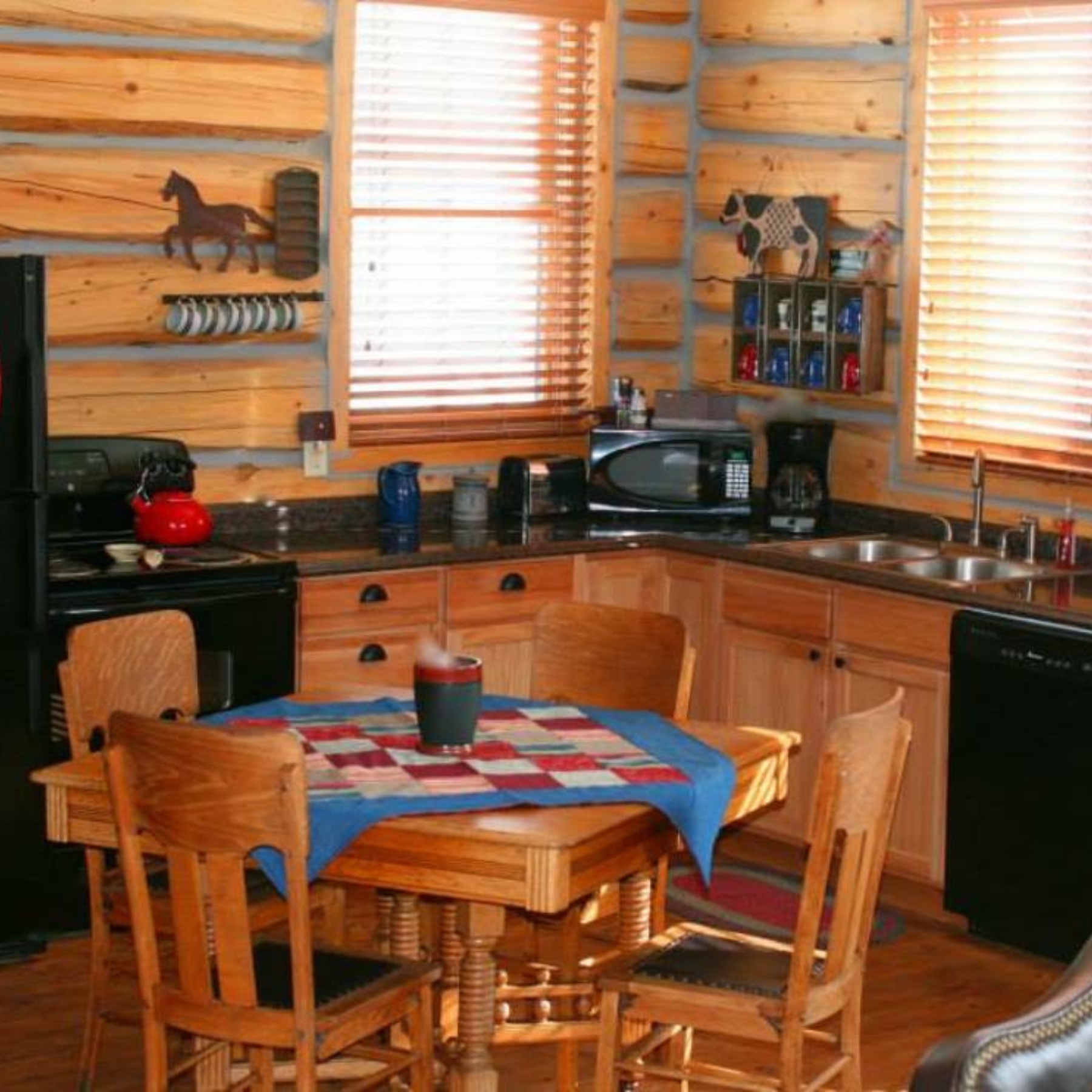 other cabin showing kitchen and eating area with custom quilts